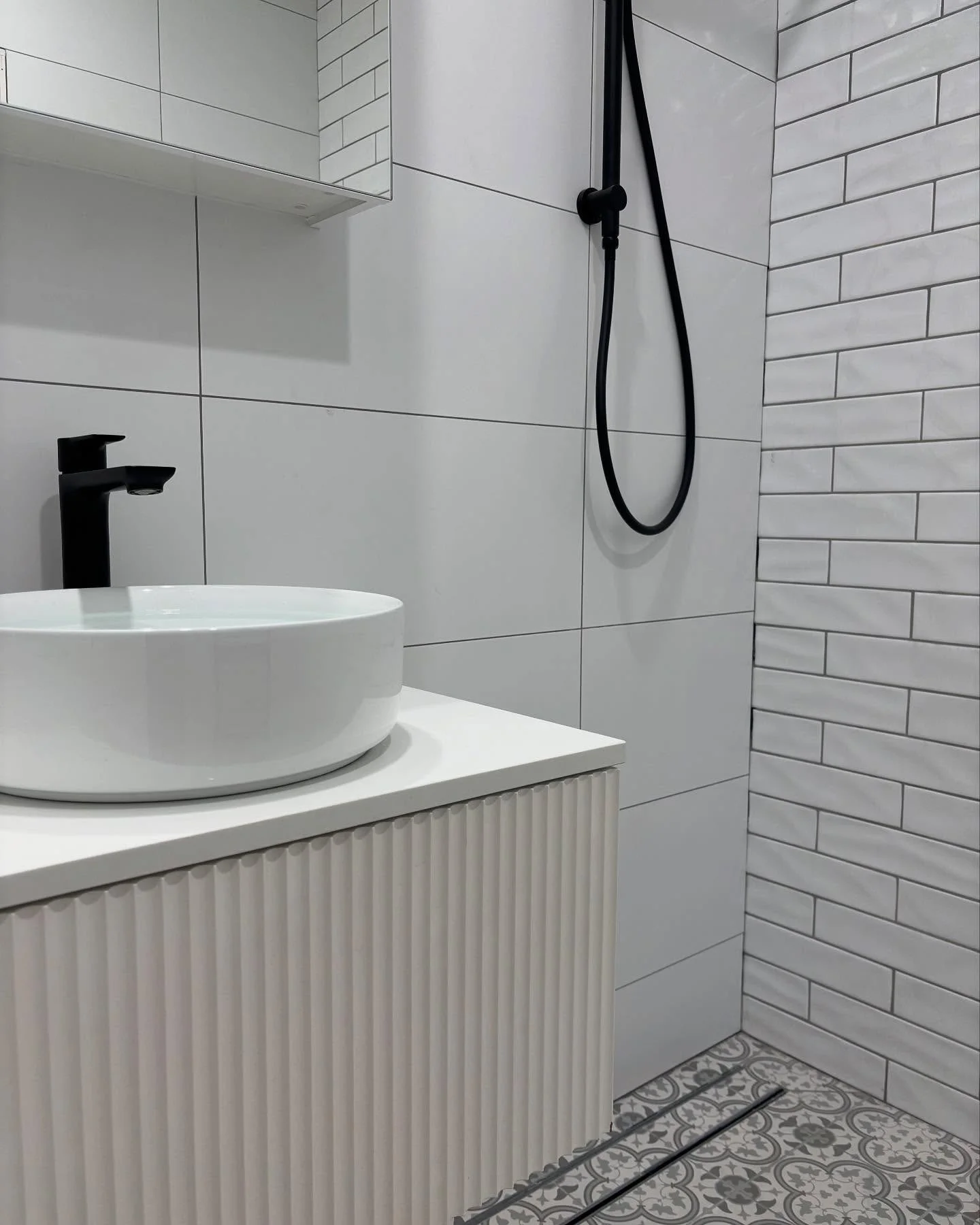 White fluted vanity and black shower fittings in an R&J bathroom renovation