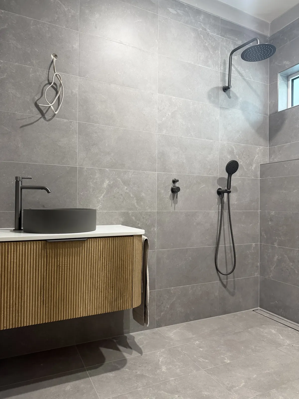 Fluted timber vanity with a dark round basin and black tapware in the Somerton Park bathroom