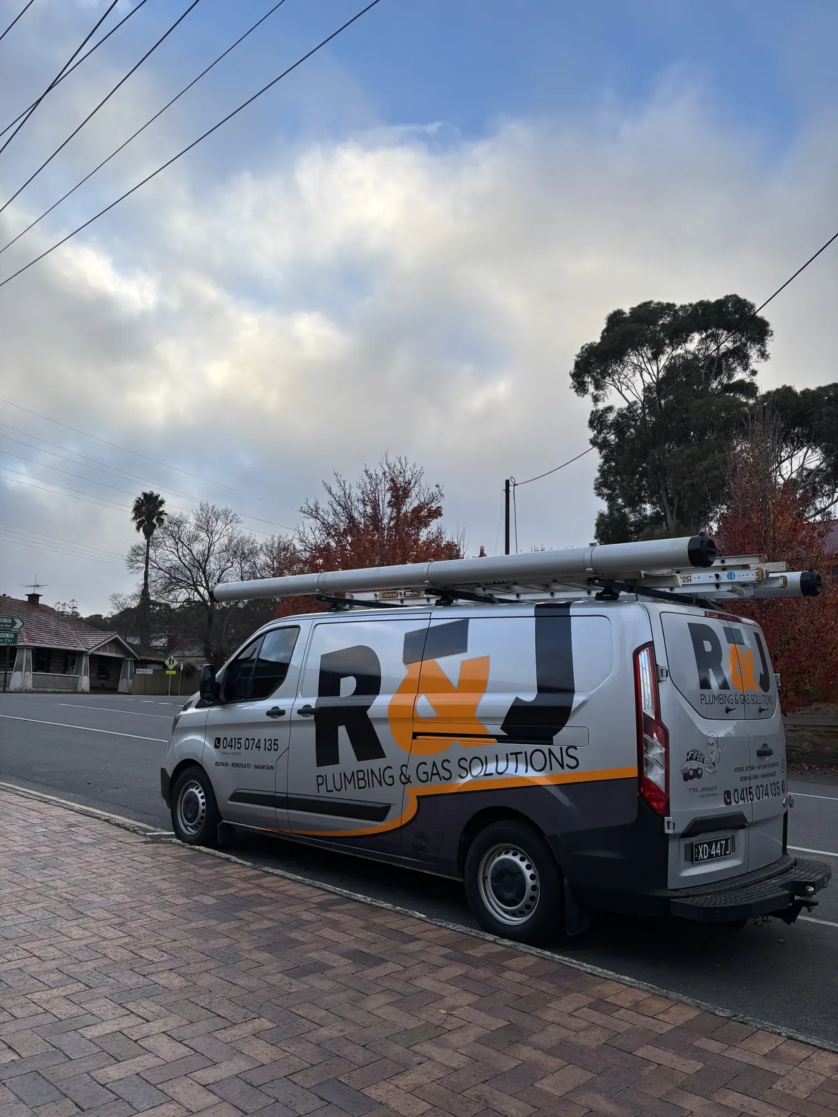 R&J Plumbing and Gas Solutions van parked on a suburban street